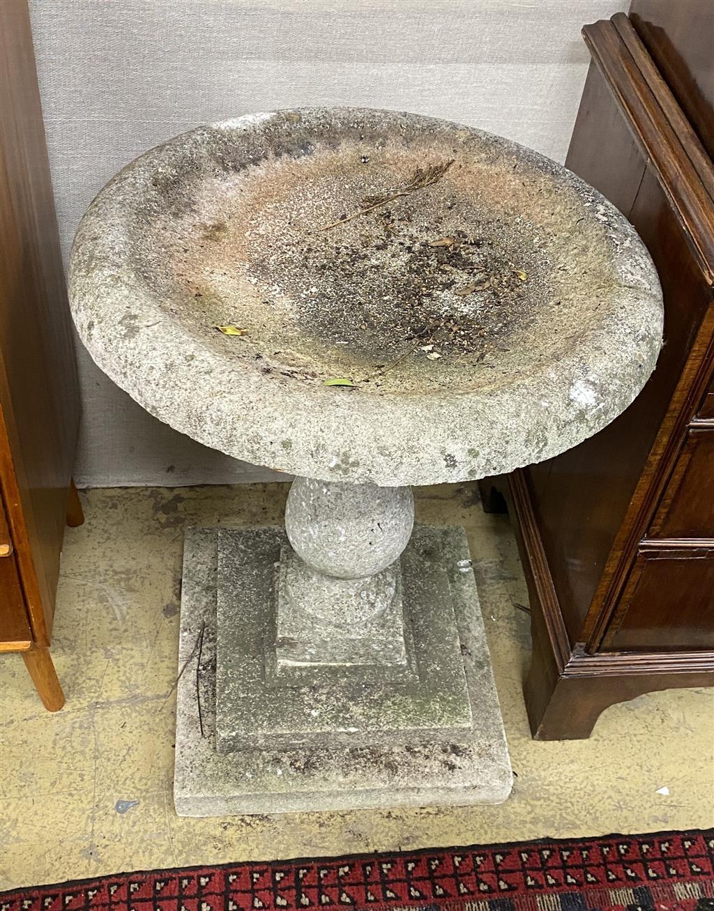 A circular reconstituted stone bird bath on stepped square plinth, 67cm diameter, height 80cm